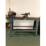 AN AXMINSTER WOOD TURNING LATHE ON STAND WITH INSTRUCTION MANUAL.