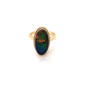 AN OPAL DOUBLET POSSIBLY TRIPLET OVAL RUBOVER SET DRESS RING. UNHALLMARKED AND ASSESSED AS 12ct
