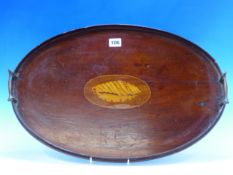 AN EDWARDIAN MAHOGANY OVAL TWO HANDLED TRAY INLAID WITH A CONCH SHELL OVAL.
