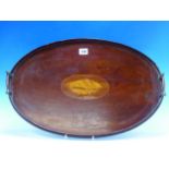 AN EDWARDIAN MAHOGANY OVAL TWO HANDLED TRAY INLAID WITH A CONCH SHELL OVAL.