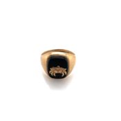 A HALLMARKED 9ct GOLD AND ONYX SIGNET RING. THE CUSHION SHAPE ONXY APPLIED WITH A CANCER