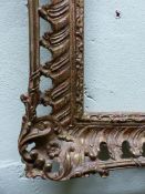 A GILT GESSO AND WOOD FRAME AND ITS GLASS, THE SIDES PIERCED WITH A LEAF BAND WITHIN CENTRAL