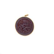 A CARNELIAN ROUNDEL INCISED WITH AN ISLAMIC TEXT, FRAMED AND MOUNTED AS A PENDANT. UNHALLMARKED