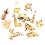 ELEVEN VARIOUS CHARMS TO INCLUDE FOUR 14ct STAMPED EXAMPLES, PINEAPPLE, ELEPHANT, EMPIRE STATE