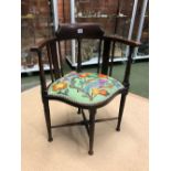 AN EDWARDIAN MAHOGANY SALON CORNER ARM CHAIR WITH EMBROIDERED SEAT PANEL.