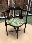 AN EDWARDIAN MAHOGANY SALON CORNER ARM CHAIR WITH EMBROIDERED SEAT PANEL.