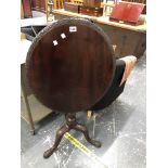 A GEORGE III MAHOGANY TILT TOP TRIPOD TABLE CARVED AT THE EDGE OF THE OVAL TOP AND ON THE LEGS. W 64