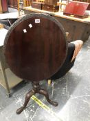 A GEORGE III MAHOGANY TILT TOP TRIPOD TABLE CARVED AT THE EDGE OF THE OVAL TOP AND ON THE LEGS. W 64