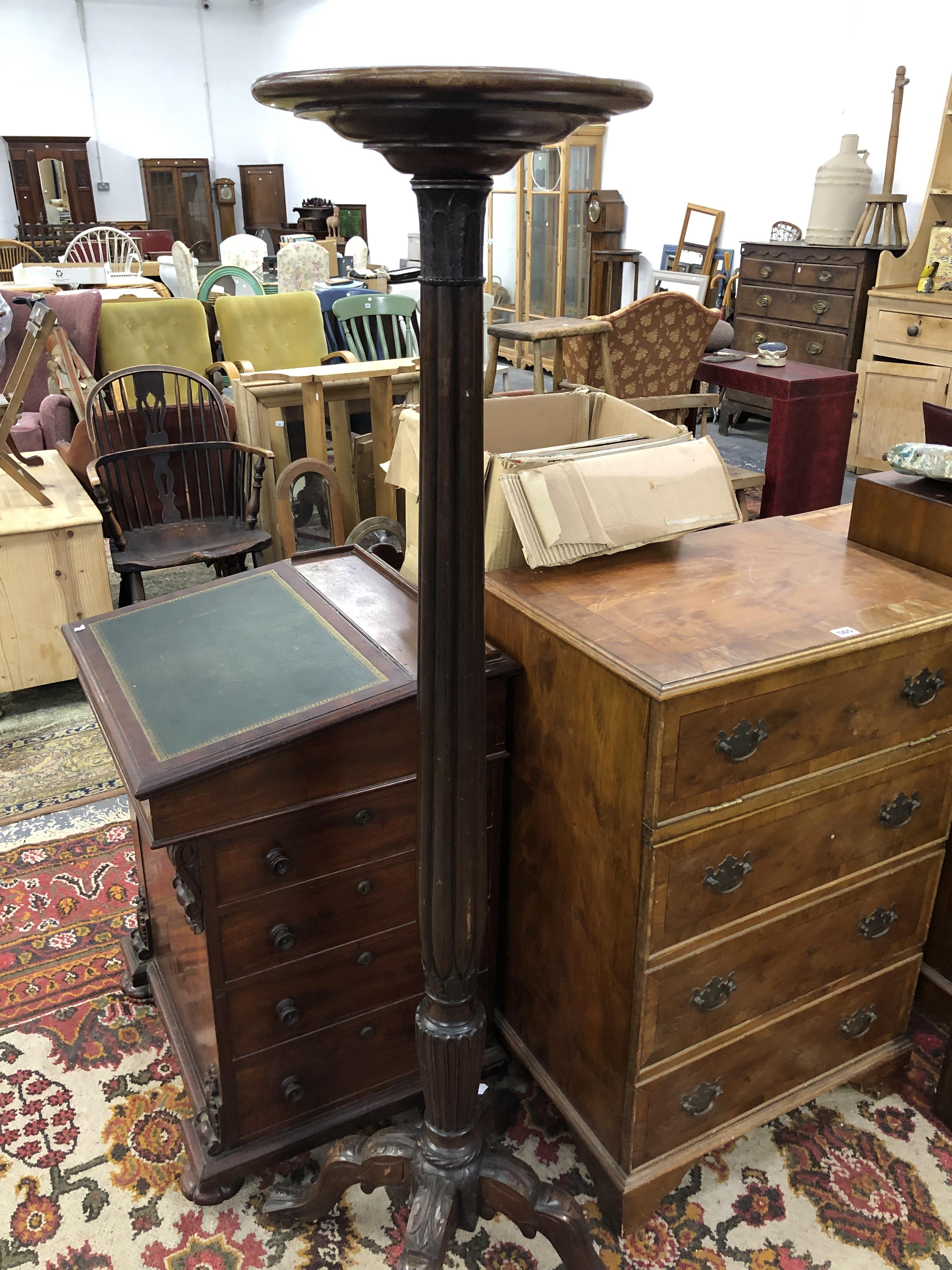 A MAHOGANY TORCHERE, THE REEDED COLUMN FLARING TO FOUR CARVED LEGS. Dia. 35x H 151cms.