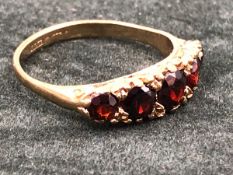 A 9ct GOLD HALLMARKED FIVE STONE GRADUATED GARNET CARVED HALF HOOP RING. FINGER SIZE Q. WEIGHT 3.