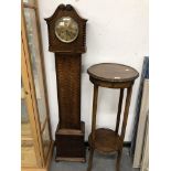 A 20th C. OAK CASED GRANDMOTHER CLOCK. H 139cms. TOGETHER WITH AN OAK TWO TIER PLANT STAND. Dia.