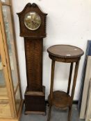 A 20th C. OAK CASED GRANDMOTHER CLOCK. H 139cms. TOGETHER WITH AN OAK TWO TIER PLANT STAND. Dia.