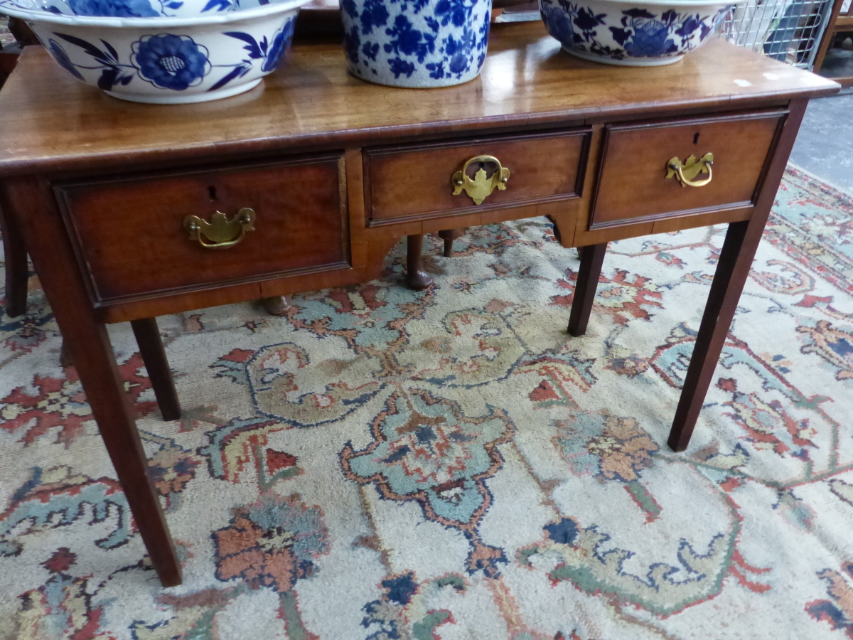 AN ANTIQUE MAHOGANY THREE DRAWER SIDE TABLE.