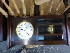 AN OAK CASED STRIKING WALL CLOCK.