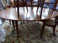 A LARGE OAK WAKE TABLE ON TURNED LEGS WITH CLUB FEET.