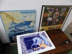 A FRAMED COLLECTION OF CLOTH BADGES, AND A SENIOR SERVICE ADVERT AND AN ENAMELLED IRON DECORATIVE