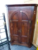 A GEORGE III MAHOGANY FLOOR STANDING CORNER CABINET WITH ARCH TOP PAIR OF PANEL DOORS.