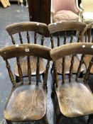 A SET OF FOUR OAK SEATED KITCHEN CHAIRS, EACH WITH FIVE TURNED UPRIGHT BARS TO THE BACK