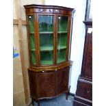 A REGENCY STYLE MAHOGANY AND INLAID SERPENTINE FRONT FLOOR STANDING CORNER CABINET.