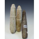 THREE WEST AFRICAN STONE PESTLES,EACH WITH RELIEF CARVED BANDS, TWO OF MARBLE AND THE LARGEST IN RED