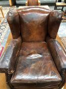 A VINTAGE BROWN LEATHER CLUB ARMCHAIR BUN FEET