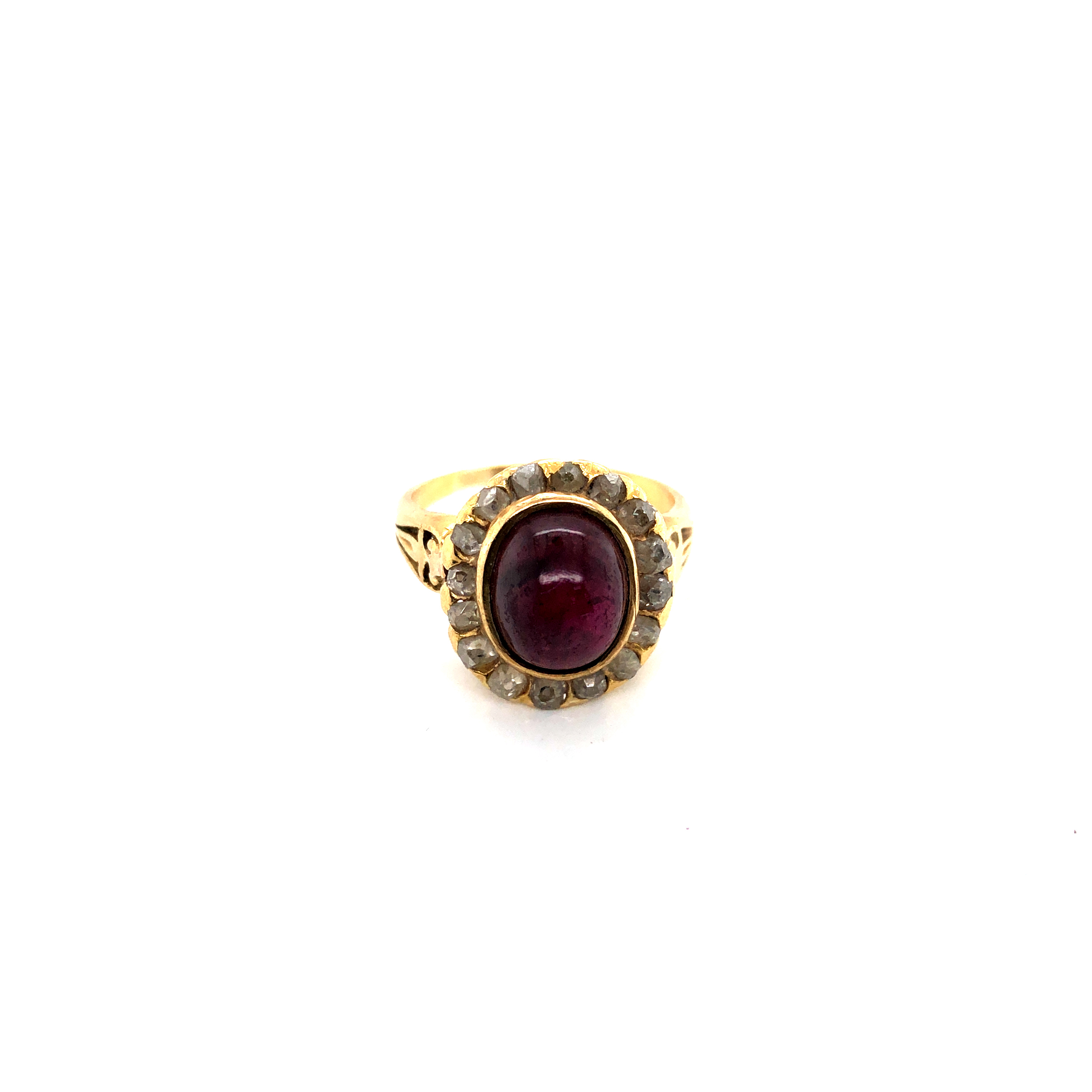 AN ANTIQUE GARNET AND DIAMOND CLUSTER RING. THE CENTRAL OVAL CABOCHON, SURROUNDED BY A CLUSTER OF