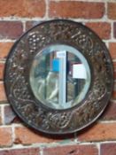 AN ARTS AND CRAFTS BEVELLED GLASS CIRCULAR MIRROR IN A COPPER MOUNTED FRAME, POSSIBLY KESWICK SCHOOL