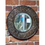 AN ARTS AND CRAFTS BEVELLED GLASS CIRCULAR MIRROR IN A COPPER MOUNTED FRAME, POSSIBLY KESWICK SCHOOL