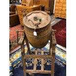A DAIRY SUPPLY Co. VINTAGE BUTTER CHURN, THE BARREL SHAPE ROTATING ABOVE A PINE STAND WITH FOUR