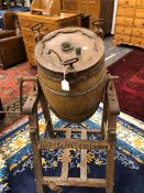 A DAIRY SUPPLY Co. VINTAGE BUTTER CHURN, THE BARREL SHAPE ROTATING ABOVE A PINE STAND WITH FOUR