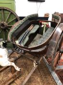 A VINTAGE HORSE DRAWN GIG WITH GREEN UPHOLSTERED SEATS AND BACK RESTS