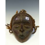 AN EARLY 20th C. YORUBA FIRE DANCE MASK CARVED WITH A CRUCIFORM ON HER FOREHEAD, STRINGS OF BEADS