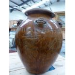 A MARTABAN MOTTLED BROWN GLAZED STORAGE JAR AND WOOD STAND, THE OVOID SHAPE WITH FIVE LION HEADS AND