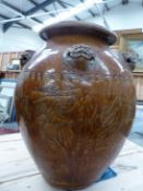 A MARTABAN MOTTLED BROWN GLAZED STORAGE JAR AND WOOD STAND, THE OVOID SHAPE WITH FIVE LION HEADS AND