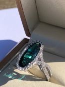 AN 18ct HALLMARKED WHITE GOLD BLUE TOURMALINE AND DIAMOND RING. THE OVAL BLUE TOURMALINE