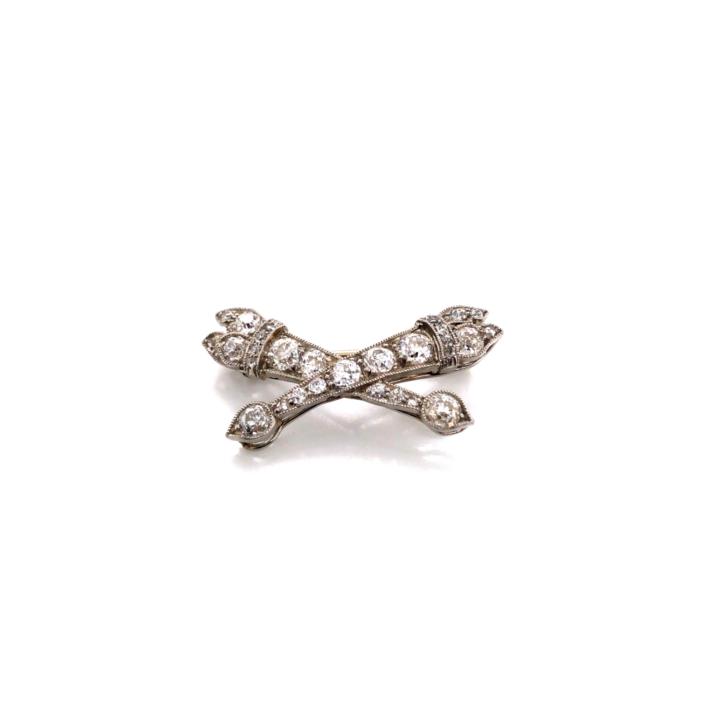 AN ANTIQUE DIAMOND SET BAR BROOCH DEPICTING CROSSED TORCHES, UNHALLMARKED ASSESSED AS PLATINUM
