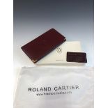 A VINTAGE BURGUNDY LEATHER CARTIER PURSE WITH ORIGINAL BOX, DUST BAG AND CERTIFICATE OF