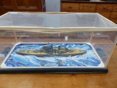 A MODEL OF THE BATTLESHIP KING GEORGE V STEAMING ACROSS OPEN WATER WITHIN ITS CASE. W 51.5cms.