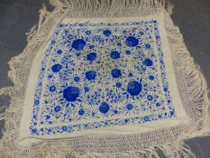 A CHINESE CREAM SILK SHAWL EMBROIDERED IN TWO TONES OF BLUE WITH FLOWERING VINES. 129 x 128cms.
