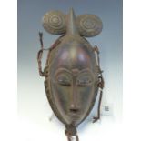 A MAHOGANY MASK, LATE 19th C. ZAIRE, THE HAIR STYLE OF TWO ROUNDELS FLANKING A PEAK, RAFFIA TIED