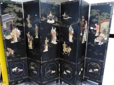 A CHINESE LACQUER AND INLAID SIX FOLD FLOOR SCREEN, DECORATED WITH FIGURES IN RELIEF IN TERRACES AND