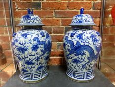A PAIR OF ORIENTAL BLUE AND WHITE DRAGON DECORATED COVERED BALUSTER VASES SIX CHARACTER MARK