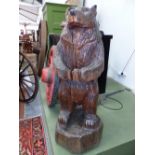 A CARVED OAK STANDING BEAR, THE FOREPAWS CLASPED IN FRONT. H 133cms.