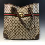 A GUCCI BROWN CANVAS LARGE TOTE BAG WITH RED AND GREEN STRIPE AND METAL EMBLEM. W 43 x H 41 cms.