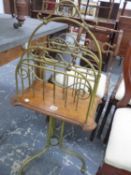 A VICTORIAN BRASS AND OAK TRIPOD MAGAZINE RACK, THE FOUR COMPARTMENTS RAISED ON AN OAK BOARD ABOVE