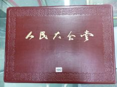 A CHINESE RED PROPAGANDA FOLIO COVERED BOX OF TWENTY COVERPLATES  OF THE GREAT HALL OF THE PEOPLE,