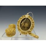 A CHINESE IVORY FLORAL CARVED OVAL EASEL BACKED FRAME. H 10cms. A DRAGON CARVED NEEDLE CASE TOGETHER