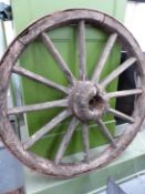 A LARGE WOODEN SPOKED CART WHEEL WITH IRON TREAD TOGETHER WITH ANOTHER SMALLER PAINTED RED