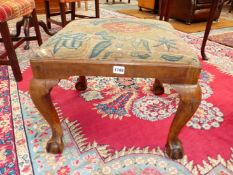 A LATE 18th C. WALNUT STOOL, THE NEEDLE WORK SEAT DROPPING IN ABOVE CABRIOLE LEGS ON BALL AND CLAW