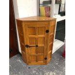 A ROBERT MOUSEMAN THOMPSON OAK CORNER CUPBOARD, THE EIGHT PANELLED DOOR FLANKED BY FOUR FURTHER